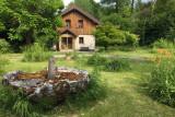 Jardin côté Ouest avec la pierre de meule du moulin en avant plan